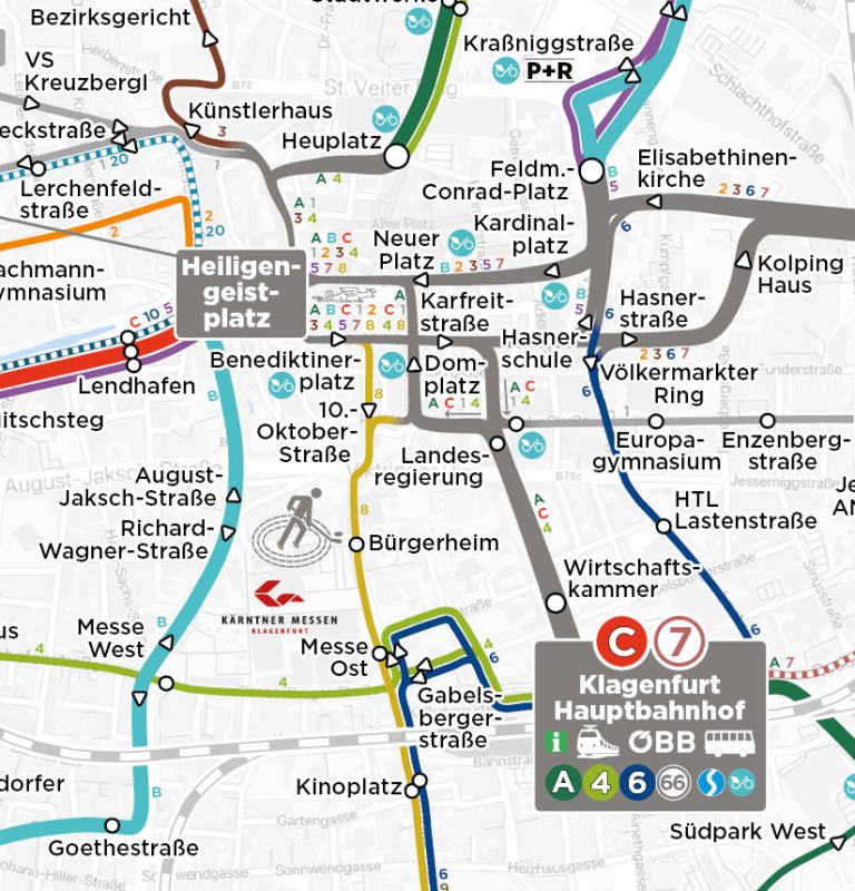 Ausschnitt des kartografischen KMG-Liniennetzes zeigt die Knotenpunkte Klagenfurt Hauptbahnhof und Heiligengeistplatz. Man sieht hier die verschiedenfärbigen Linien mit den jeweiligen Haltestellen, die von diesen Knotenpunkten aus in alle Himmeslrichtungen fahren.